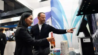 Trinh Le-Fiedler, CEO and Co-Founder of Nomitri, and Michael Scheibner, CEO at GK, mark the integration of Nomitri’s computer vision solutions into GK’s Cloud4Retail platform at NRF 2025. (Photo: GK Software)