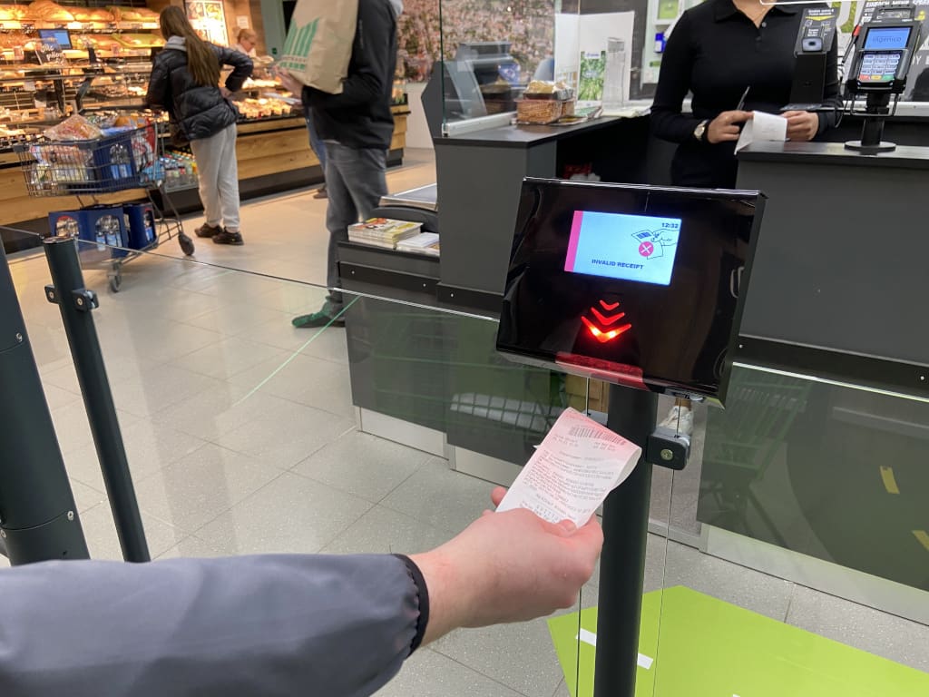 Marktkauf Lübbecke – SCO-Kunden öffnen die Schranke durch Einlesen des Barcodes auf ihrem Kassenbon.