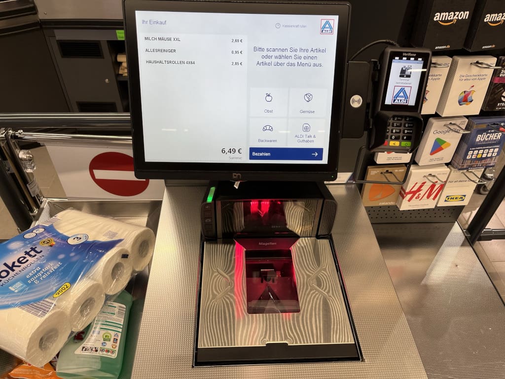 Similar to its competitor Lidl, the discounter is using GK's software consistently for both manned checkouts and self-checkouts. (Photo: The Retail Optimiser)