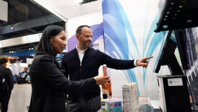 Trinh Le-Fiedler, CEO and Co-Founder of Nomitri, and Michael Scheibner, CEO at GK, mark the integration of Nomitri’s computer vision solutions into GK’s Cloud4Retail platform at NRF 2025. (Photo: GK Software)