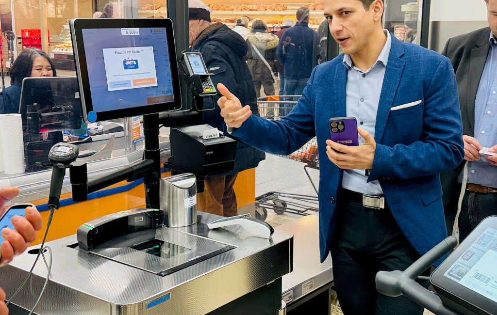 Kevin Müller von Shopreme freut sich über einen erfolgreichen Abschluss des Einkaufs mit Fastlaner an Wanzls Self-Checkout. (Foto: Björn Weber / Retail Optimiser)